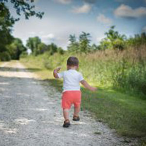 Toddler running photo. Image of a toddler running down a dirt road.