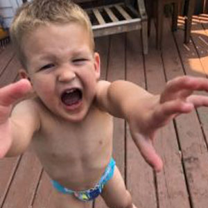 Photo of a young boy throwing a tantrum. Outdoor photo.