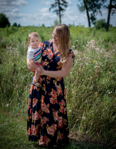 Taking Space blog image. Photo of Jessie holding her son outside. Field and trees in the background.