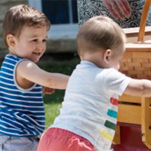 ABA therapy for kids image. Photo of two young children pushing a wagon.