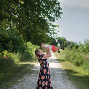 Photo of a mom holding her child in the air.