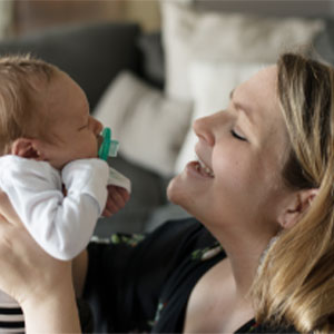 Mother talking to her newborn child. Photo of a mom holding her newborn child in the air.