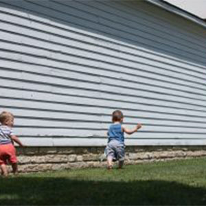 Children playing outside. Two young children playing on the side of a house.