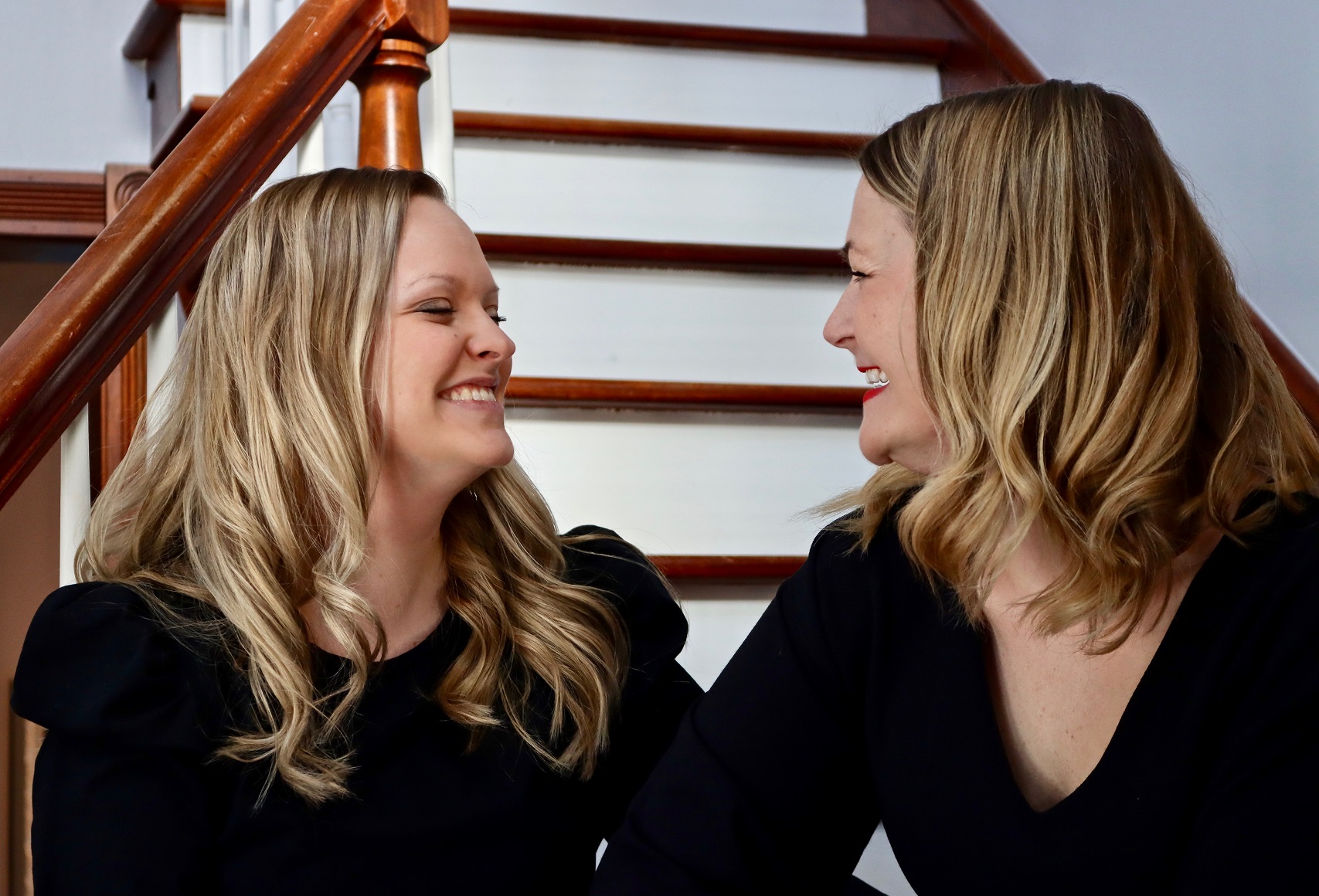 Too Strong for Who? blog featured image. Photo of Jessie and her sister sitting on staircase and sharing a laugh.