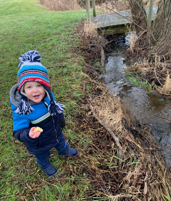 Walking Home to Ourselves blog featured image. A photo of Jessie's son standing next to a creek.