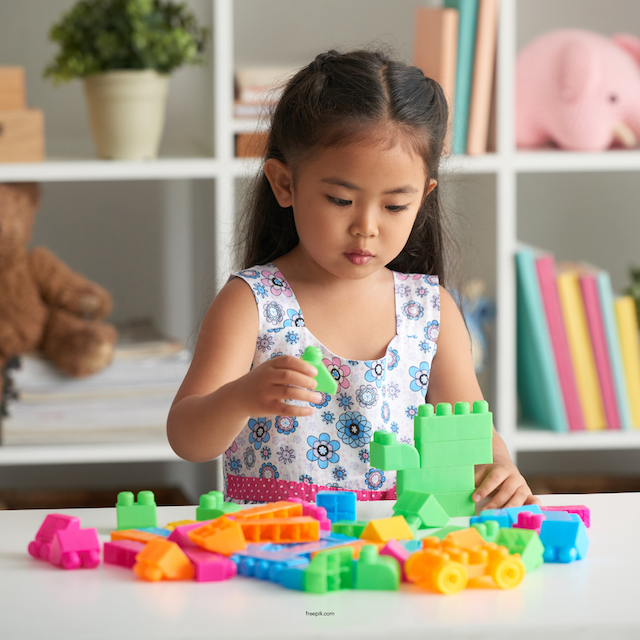 What are the Signs of High Functioning Autism blog image. Photo of a young girl playing with blocks.