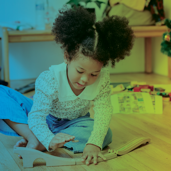 Signs of Autism in Girls blog image. Photo of a young girl building with toys.