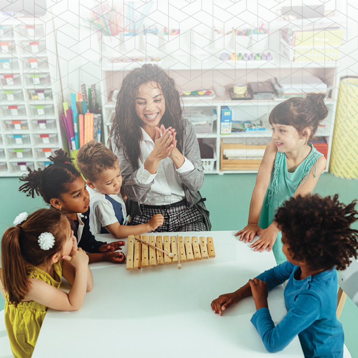 Choosing Daycare Programs for Children with Autism blog image. Photo of a teacher and her students in a classroom.